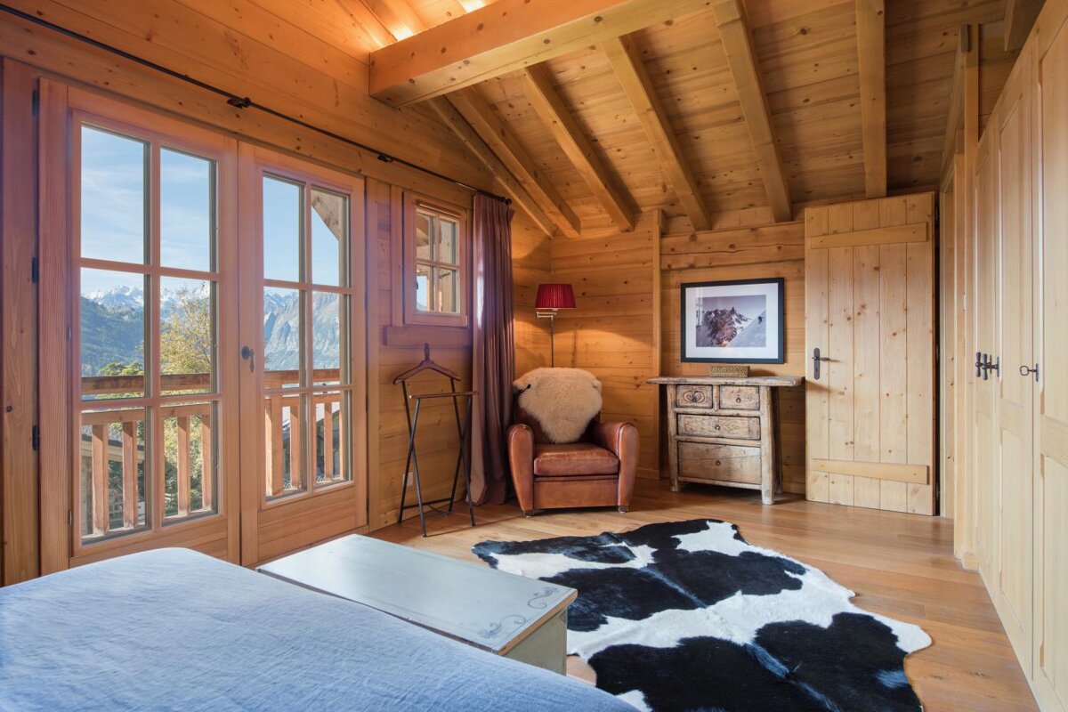 A bedroom with a cow print rug and a chair