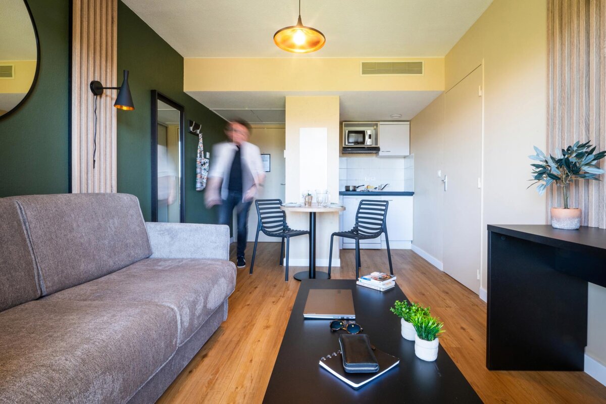A living room with a couch and a table and chairs