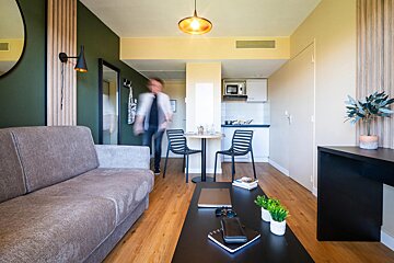 A living room with a couch and a table and chairs