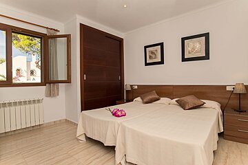 A bedroom with two beds and two pictures on the wall