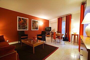 A living room with red walls and orange curtains