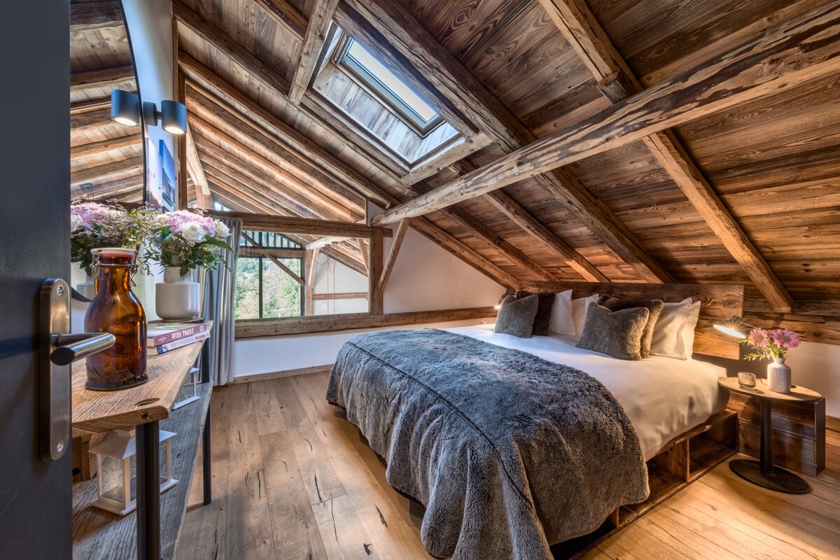 A bedroom with a bed and a skylight in the ceiling