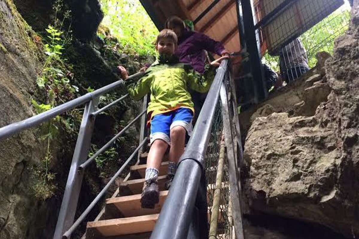 a young boy walking down some steps in a gorge