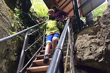 a young boy walking down some steps in a gorge