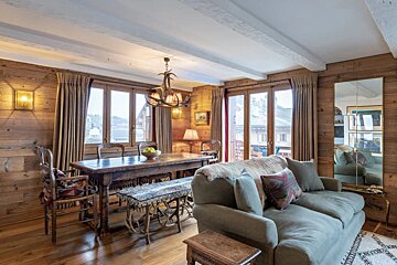 A living room with a couch a table and chairs