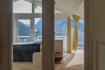 A bedroom with a bed and a view of the mountains