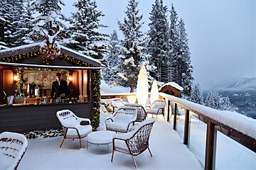 A man in a suit stands behind a snow covered bar
