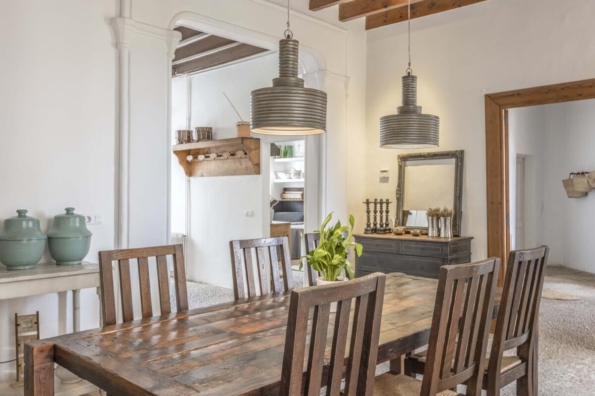 A dining room with a wooden table and chairs