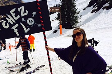 a woman holding a flag saying chez flo in avoriaz