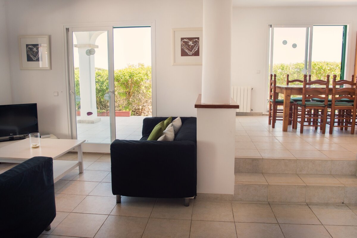 A living room with a black couch and a white coffee table