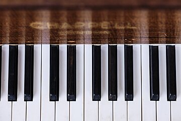 A close up of a chapell grand piano keyboard