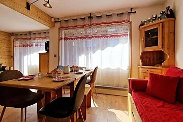A living room with a dining table and chairs