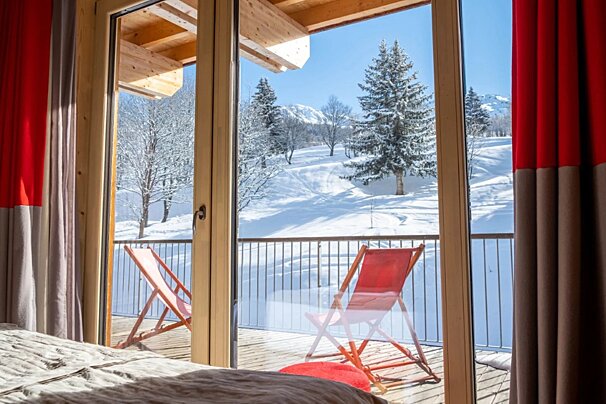 A balcony with a view of snow covered trees and mountains