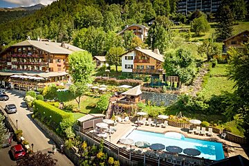 An aerial view of a hotel with a large swimming pool
