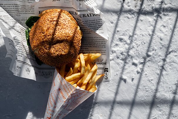 A hamburger and french fries wrapped in la savoie paper