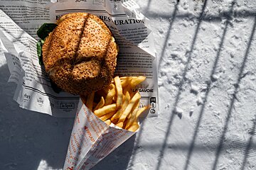 A hamburger and french fries wrapped in la savoie paper