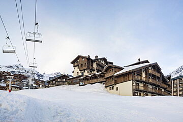 A ski lift is going up a snow covered slope