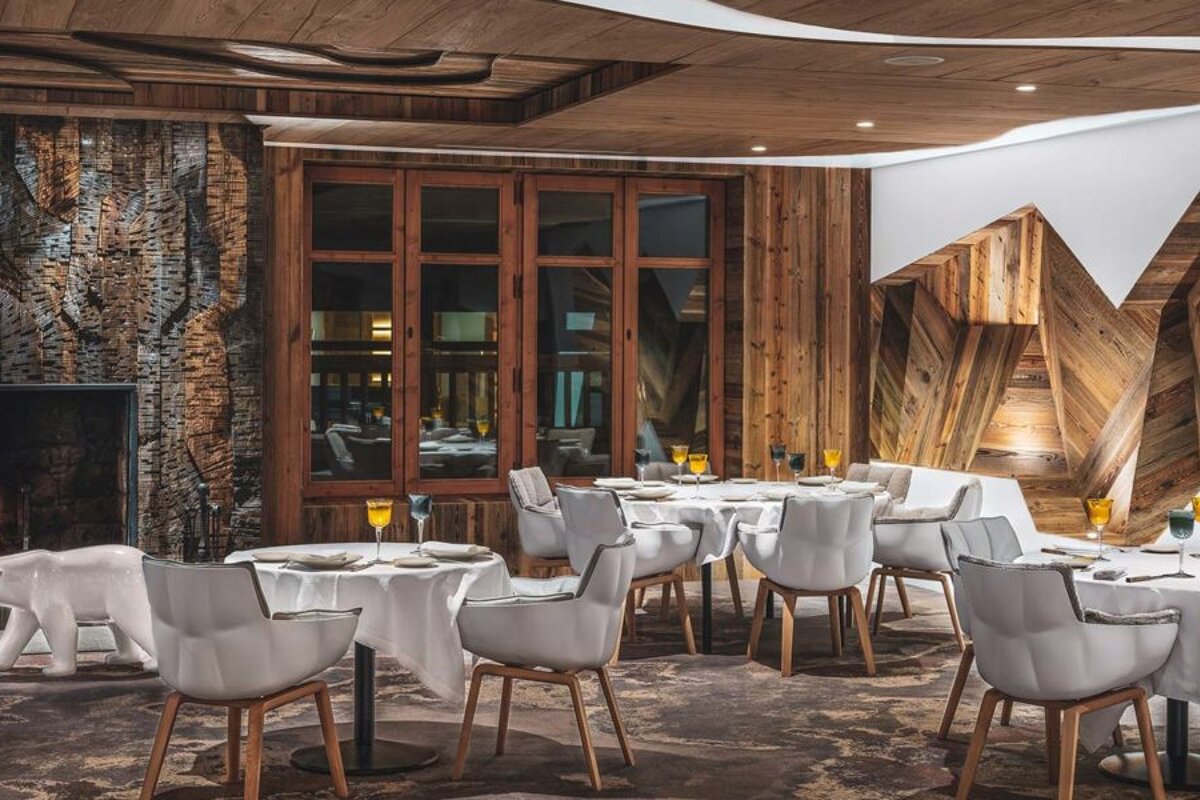 A dining room with tables and chairs and a fireplace