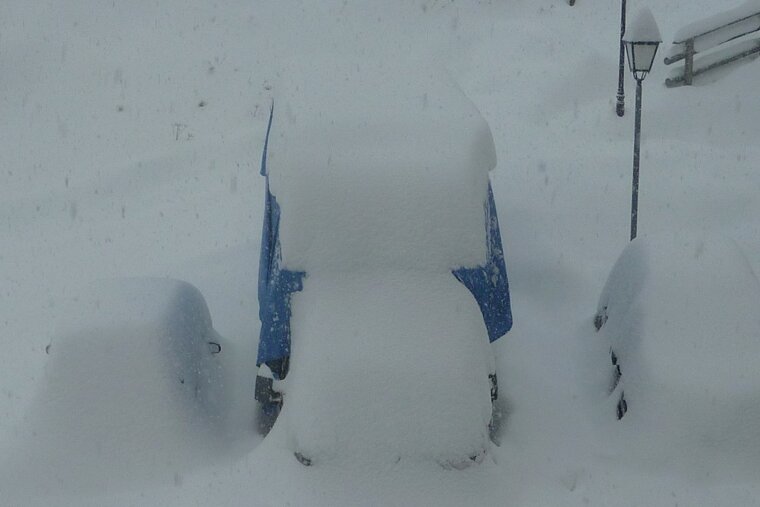 snow covered cars and van in val disere
