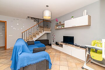 A living room with a blue couch and a television