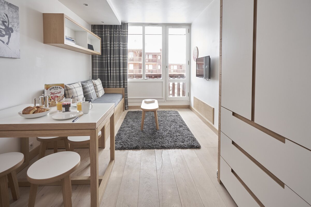 A living room with a couch and a table with a sign on the wall that says