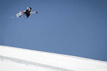 Snowboarder airing half pipe