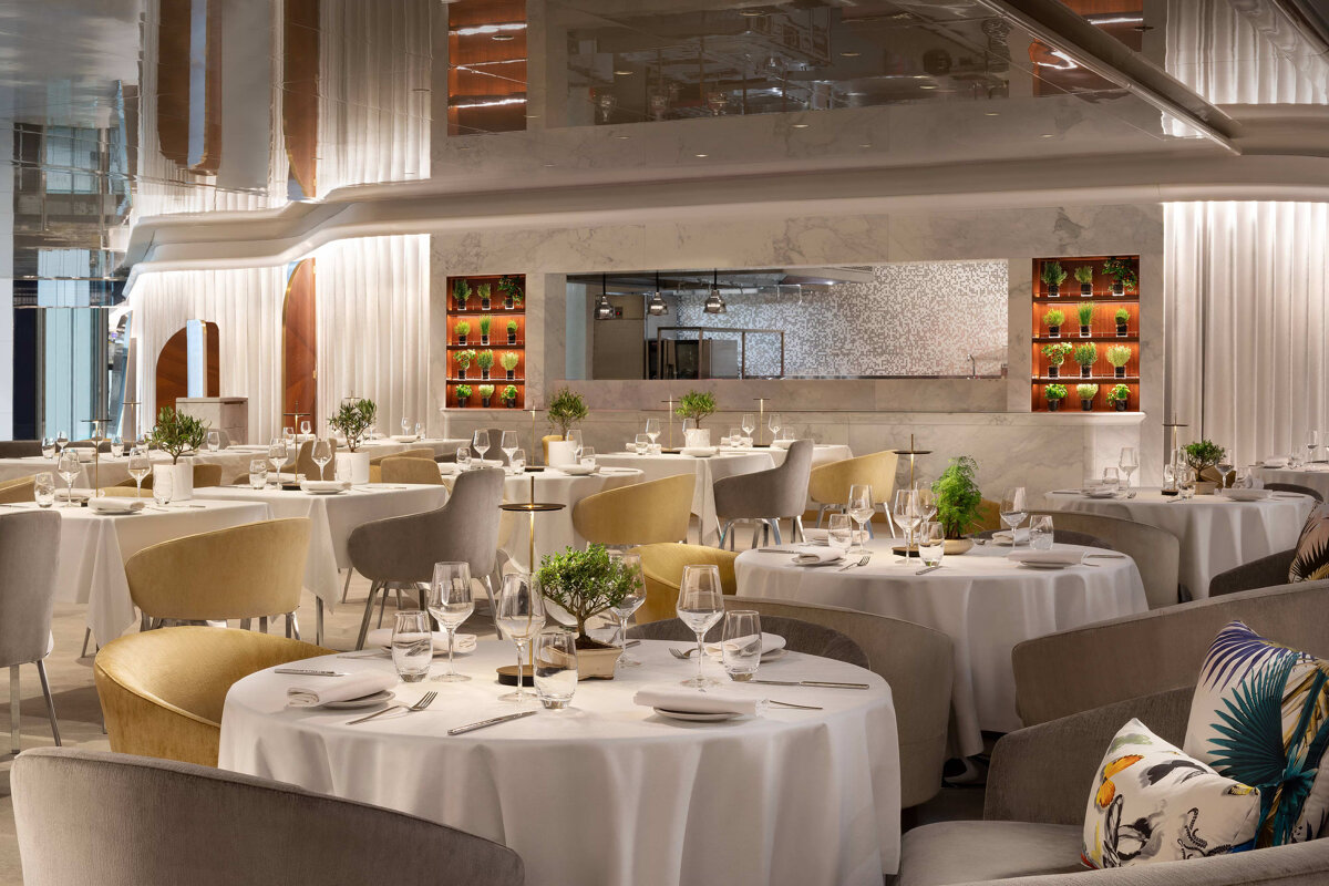 A restaurant with white tables and yellow chairs