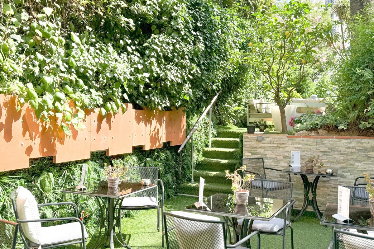 A garden with tables and chairs and a sign that says ' a ' on it