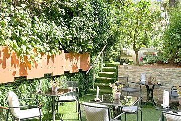 A garden with tables and chairs and a sign that says ' a ' on it