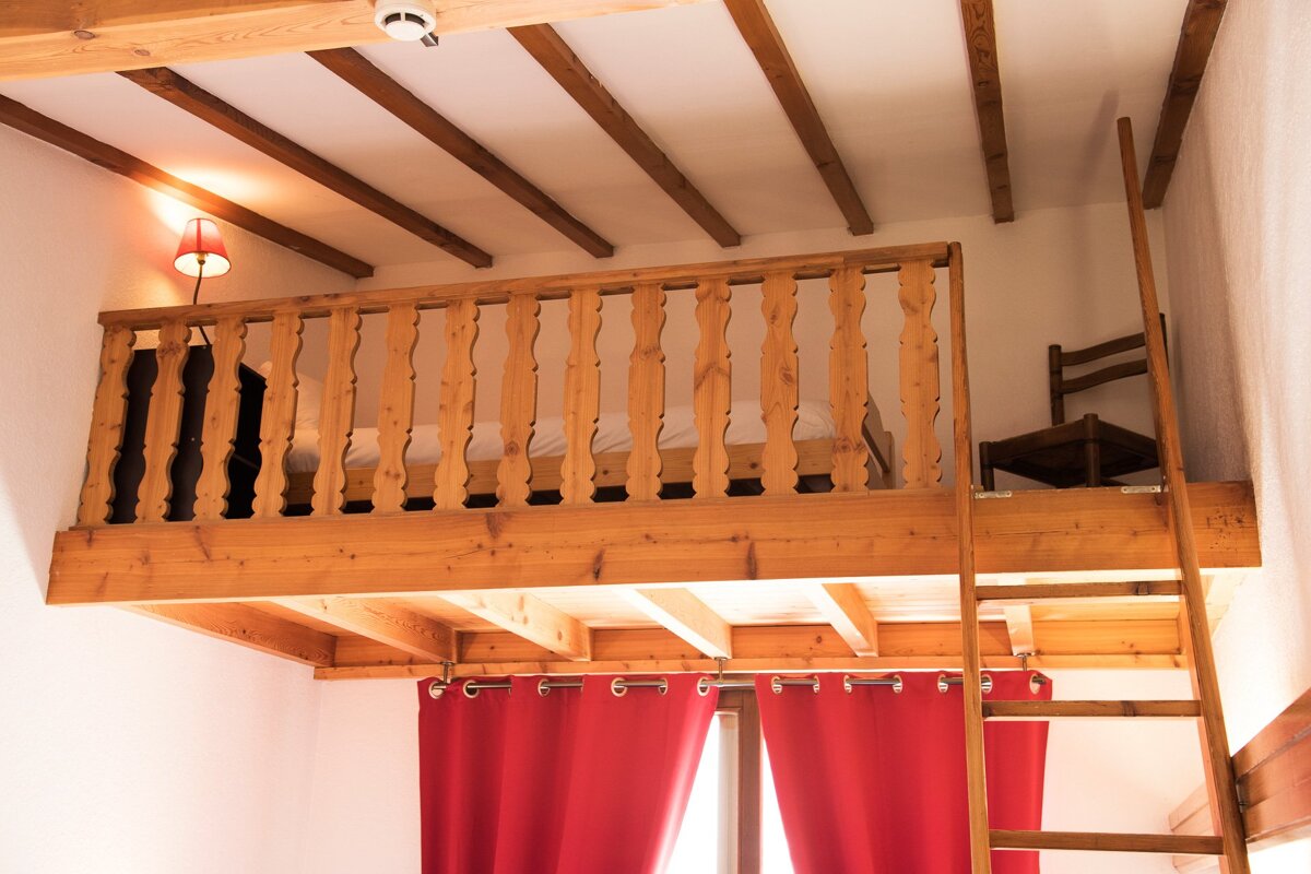A wooden balcony with a ladder leading up to it