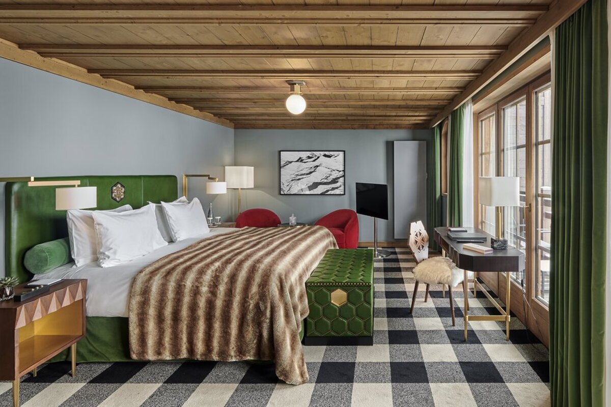 A bedroom with a large bed and a desk