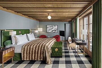 A bedroom with a large bed and a desk