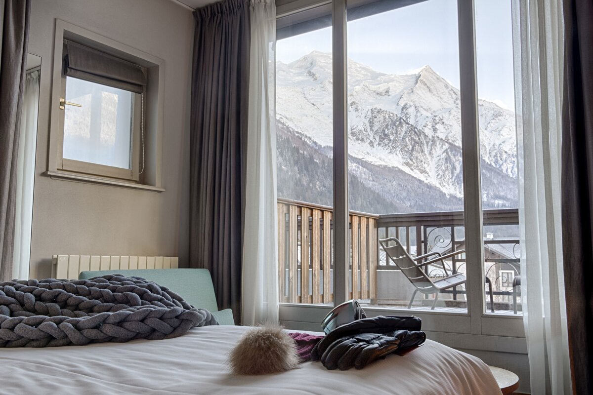 A bedroom with a view of a snowy mountain