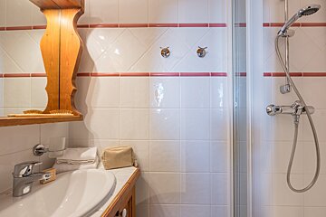 A bathroom with a sink a mirror and a shower