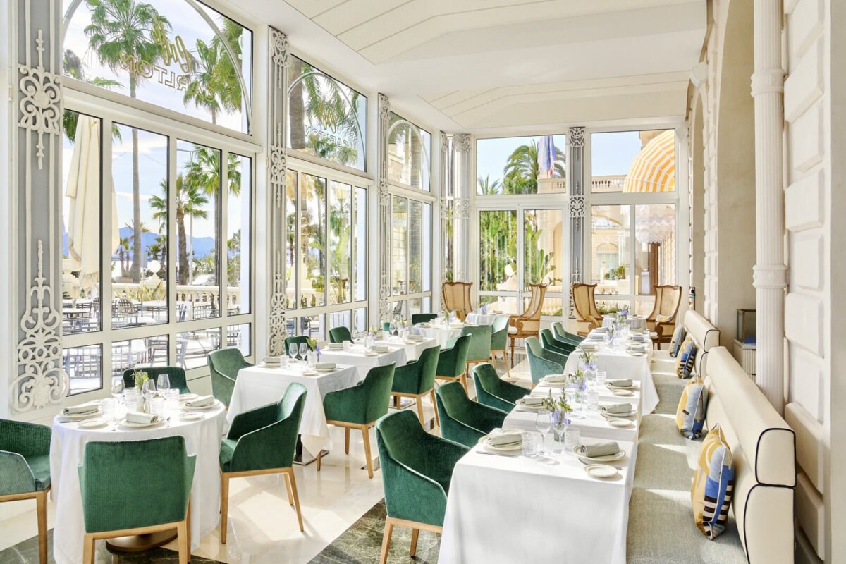 A dining room with tables and chairs and the word hotel on the wall