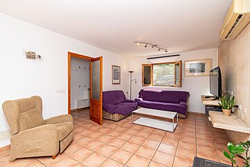 A living room with a purple couch and a brown chair
