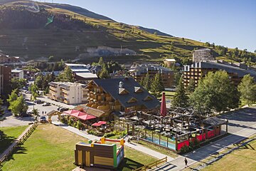 An aerial view of a ski resort with a bouncy house in the foreground