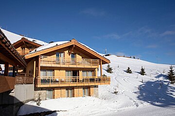 A snowy house with a blue sky in the background