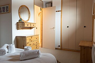 A bedroom with a bed dresser and mirror