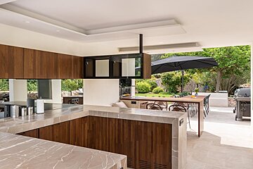 A kitchen with wooden cabinets and marble counter tops