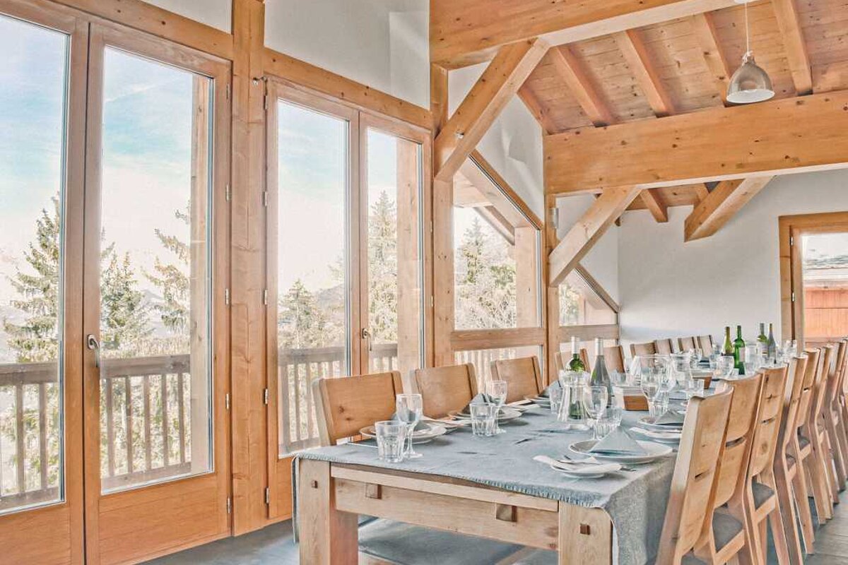 A long dining table with a table cloth and glasses on it
