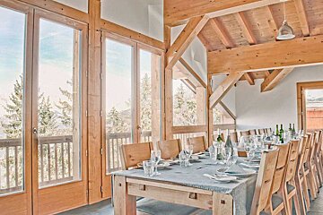 A long dining table with a table cloth and glasses on it