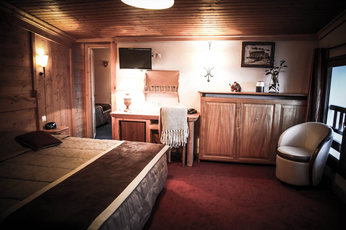 A bedroom with a bed a desk and a chair