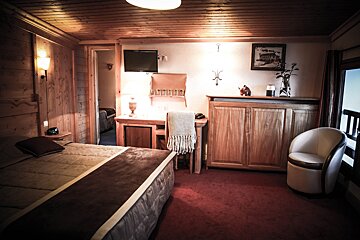 A bedroom with a bed a desk and a chair