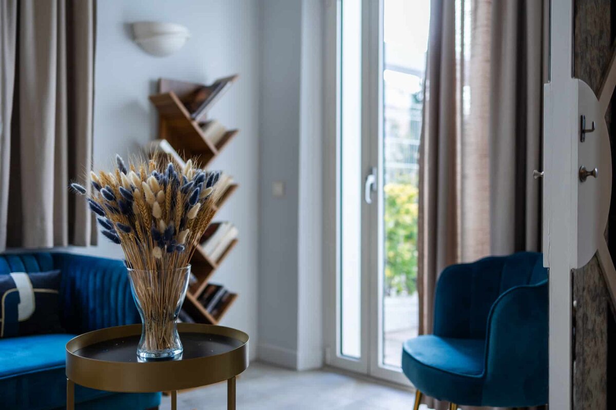 A vase of dried flowers sits on a table in a living room