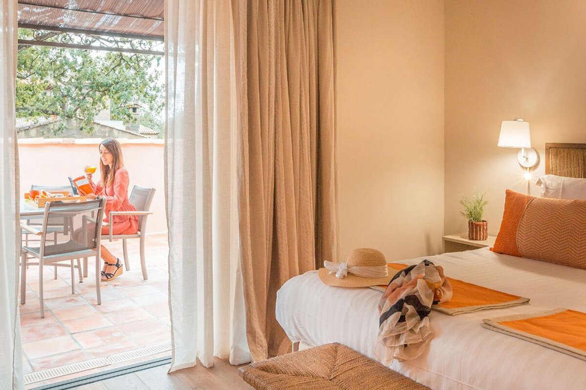 A woman sits at a table in a hotel room