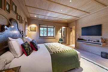 A bedroom with a large bed and a flat screen tv