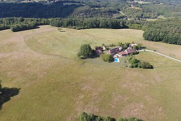 An aerial view of a house in the middle of a field