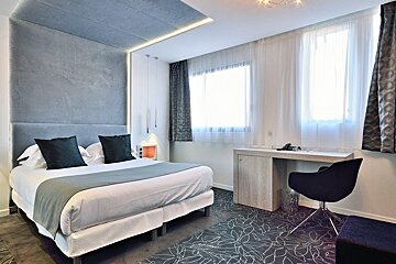 A hotel room with a king size bed and a desk