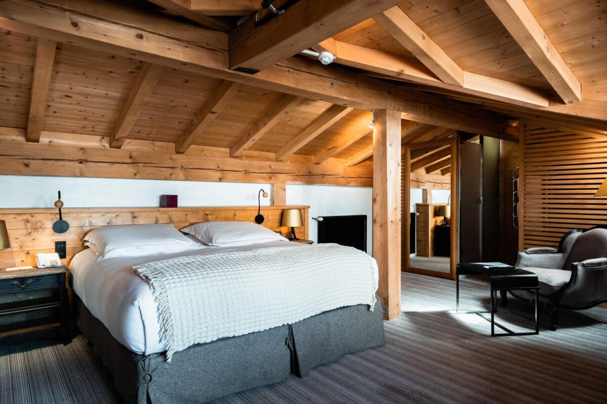 A bedroom with a wooden ceiling and a bed